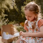Girl pressing flowers with an eco wooden flower press kit