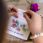 Girl threading beads on charm bracelets party bags